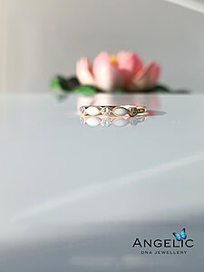 The Angelic Two Marquisette Three Genuine Birthstones DNA Ring features a gold band with two marquisette-shaped settings and three genuine birthstones, ideal for personalized jewelry.